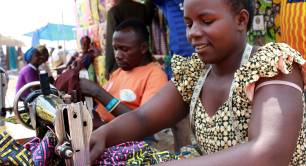 Woman works with sewing machine at an Ugandan market